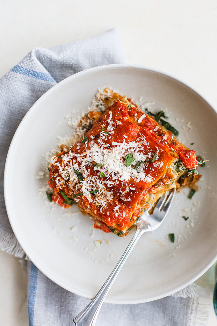 veggie lasagna on a white plate with a fork