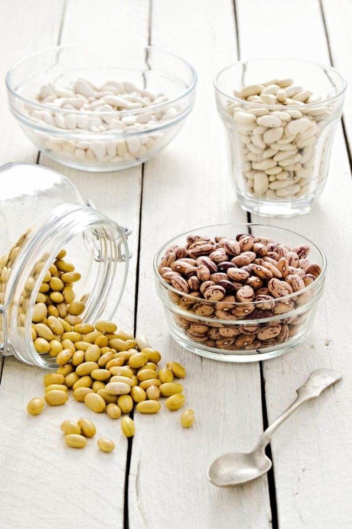 clear glass bowls of dried beans on a wooden table