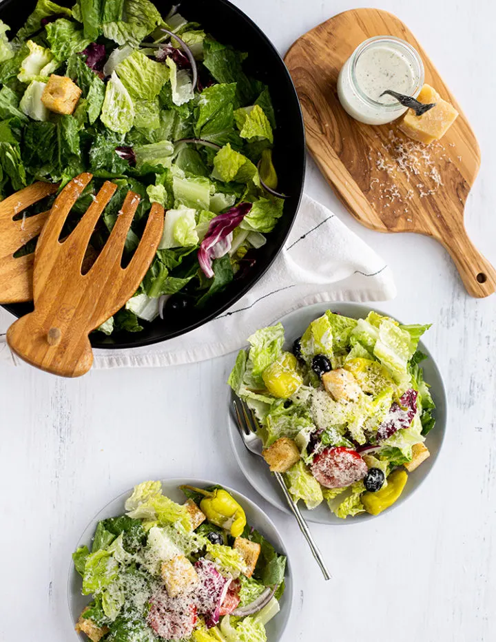 overhead shot of olive garden salad being served on a farmhouse dining table