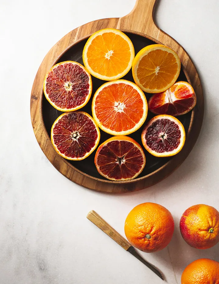 different types of oranges on a cutting board to cut into segments