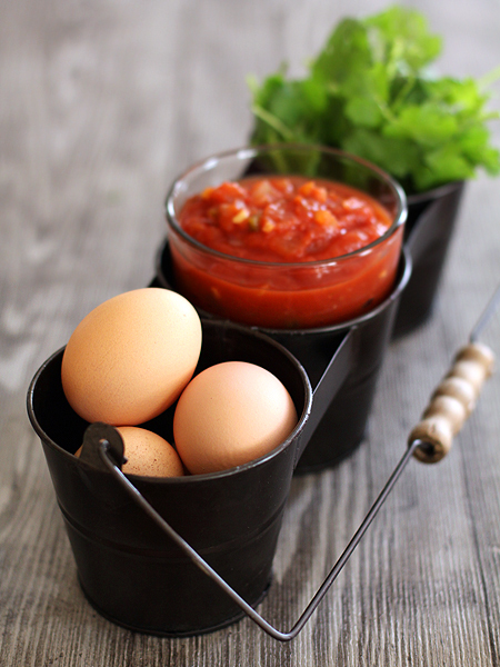 small black metal pails with eggs, salsa, and cilantro for making black bean burritos