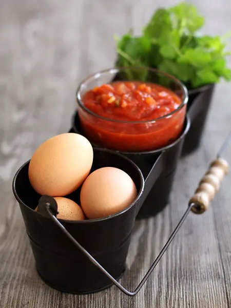 small black metal pails with eggs, salsa, and cilantro for making black bean burritos