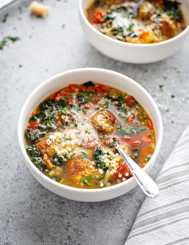 white bowl with italian wedding soup and chicken meatballs