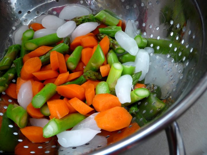 carrots and asparagus in a strainer for a chicken asparagus stir fry recipe