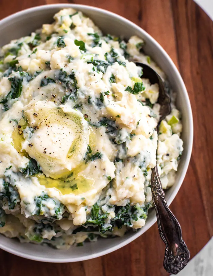overhead close up shot of a bowl of kale and leek colcannon (irish mashed potatoes)