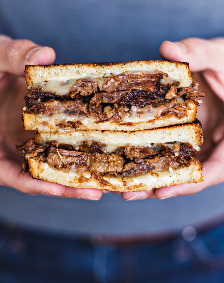 photo of a man holding a french dip panini