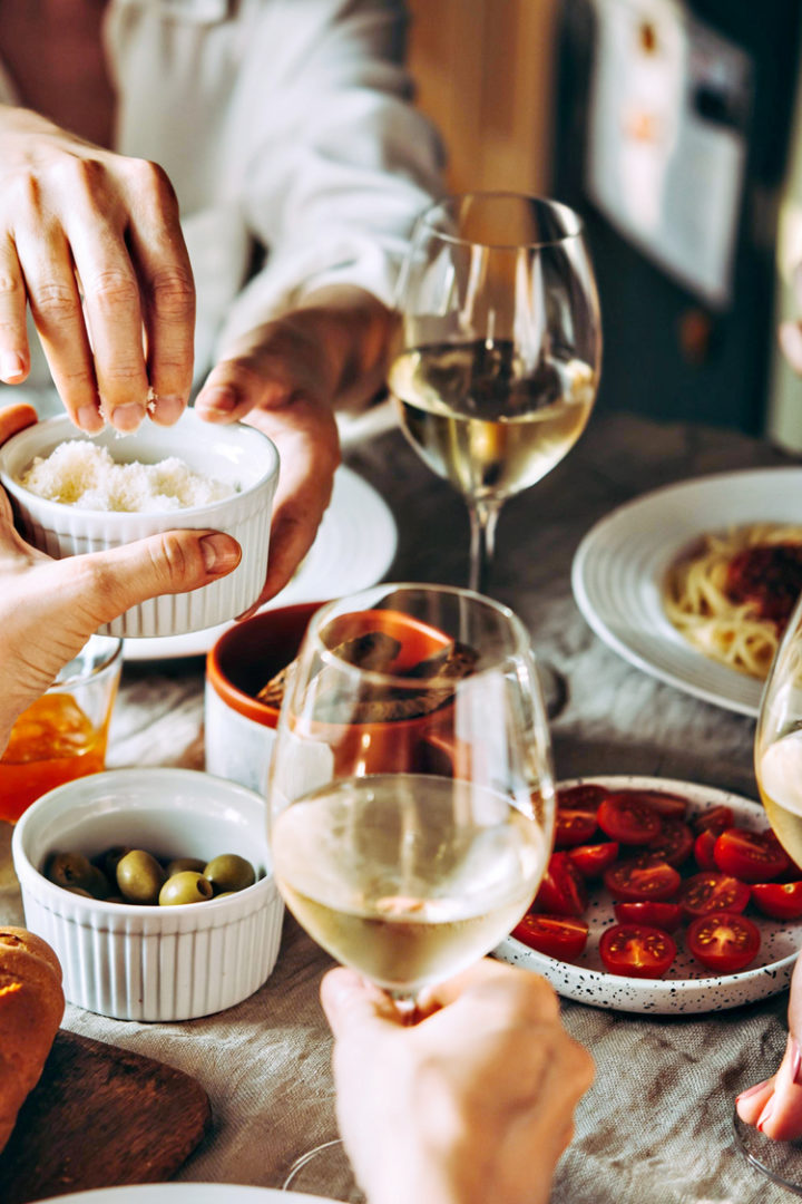 a group eating a meal with glasses of wine