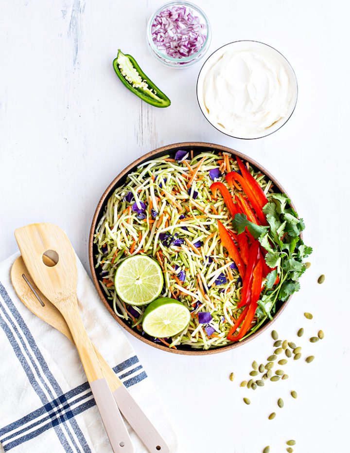 overhead shot of ingredients to make cilantro lime broccoli slaw in a bowl