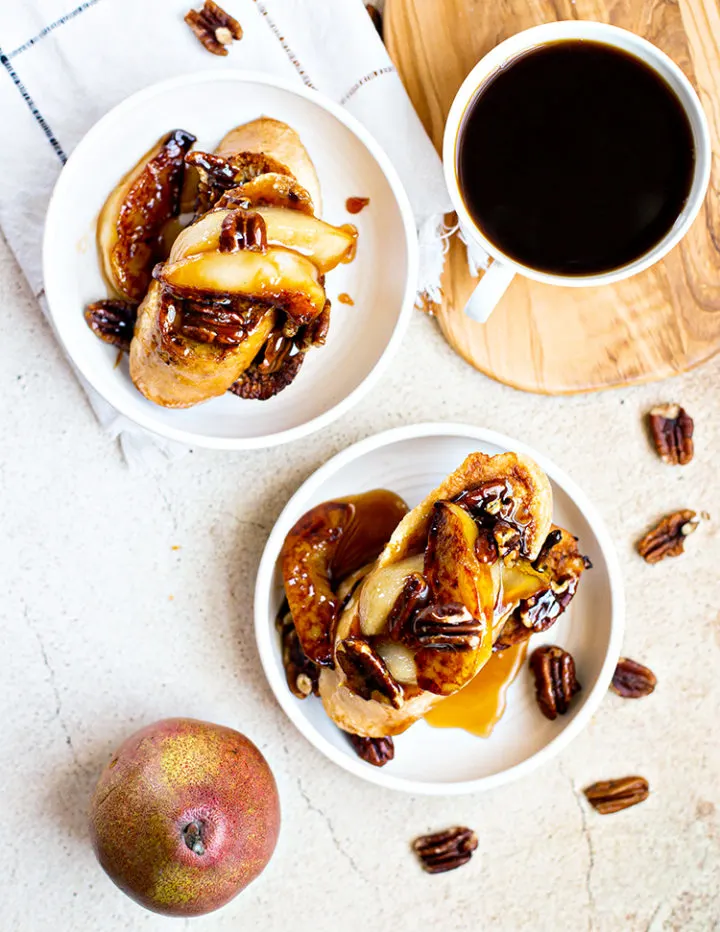 overhead photo of place of pecan french toast with pears and a mug of coffee