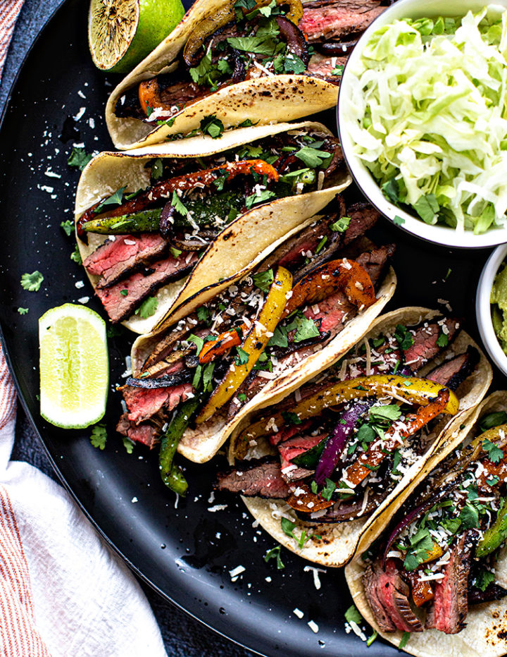 photo of a platter of flank steak fajitas with lettuce