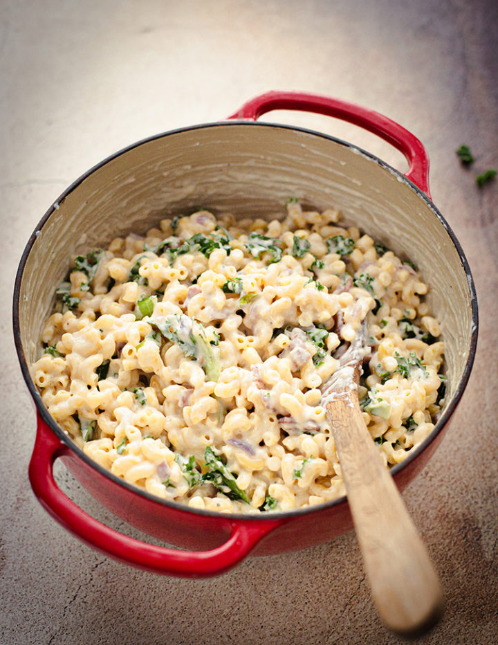 stirring a pot White Cheddar Mac and Cheese with kale and bacon