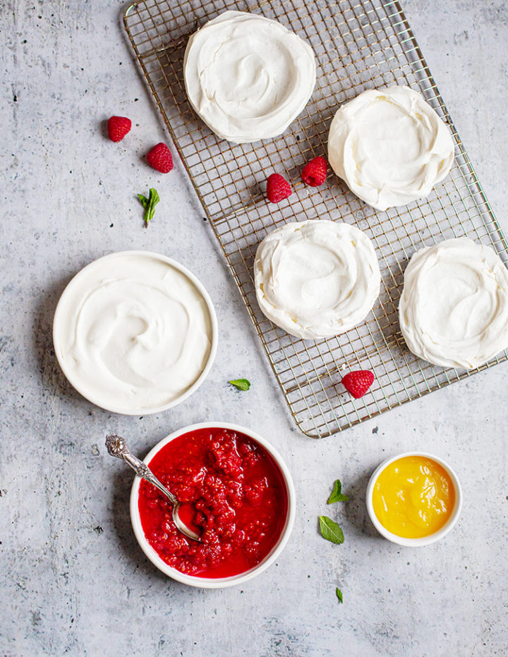 a photo of meringue nests for making pavlova dessert with raspberries and lemon curd