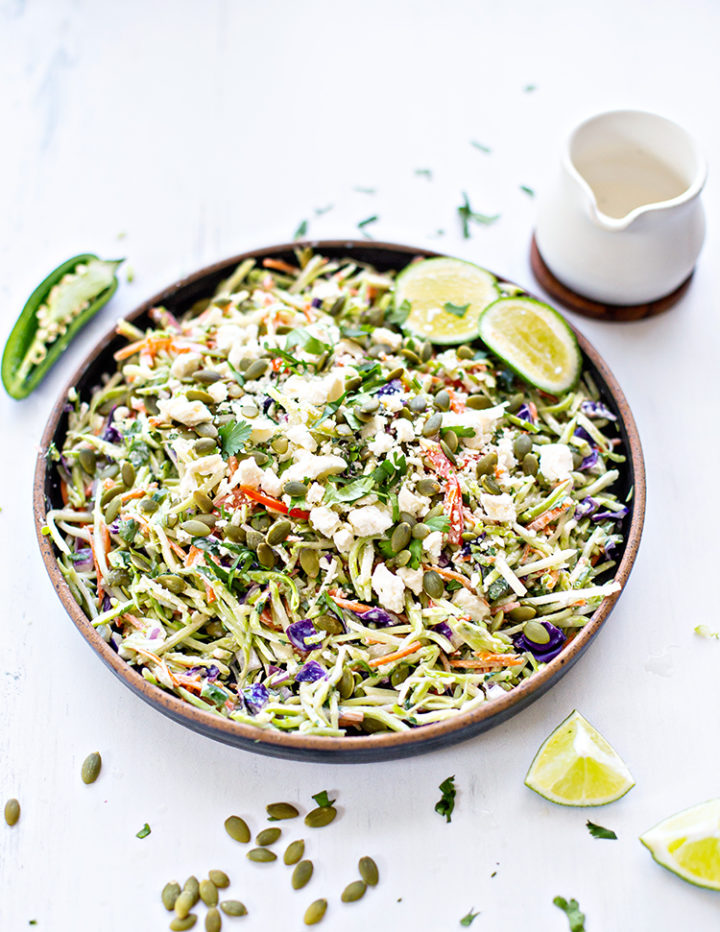 photo of a bowl of cilantro lime broccoli slaw with jalapeno, lime, pepitas, and cheese