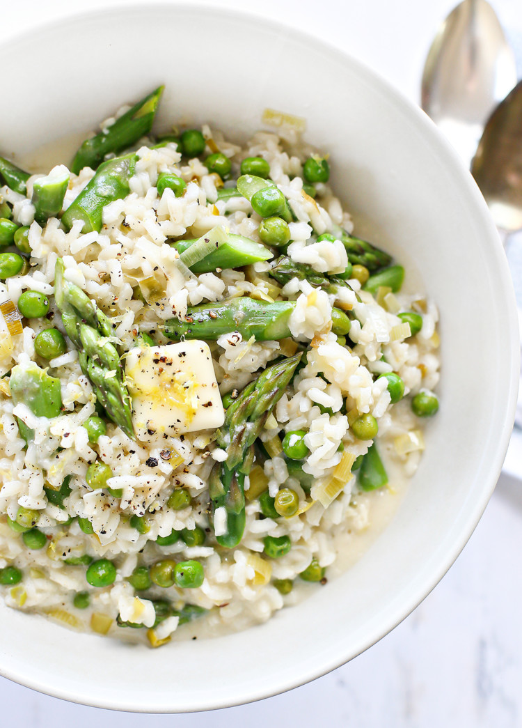 A bowl of asparagus risotto with lemon, featuring creamy arborio rice, vibrant green peas, sautéed leeks, and fresh asparagus spears. Topped with butter, lemon zest, and cracked pepper, this spring dinner is warm, fresh, and full of seasonal flavor.