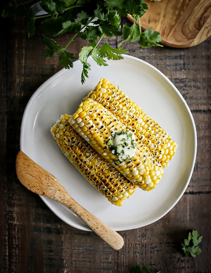 photo of grilled corn on a plate with cilantro lime butter