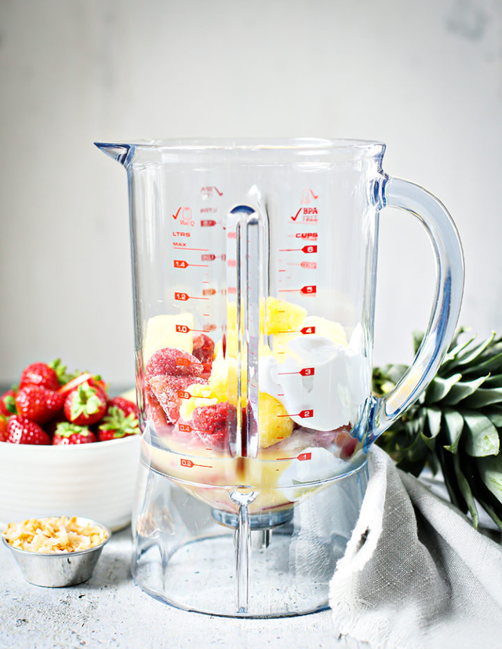 photo of ingredients for a Strawberry Pineapple Smoothie in a blender to show how to make the recipe
