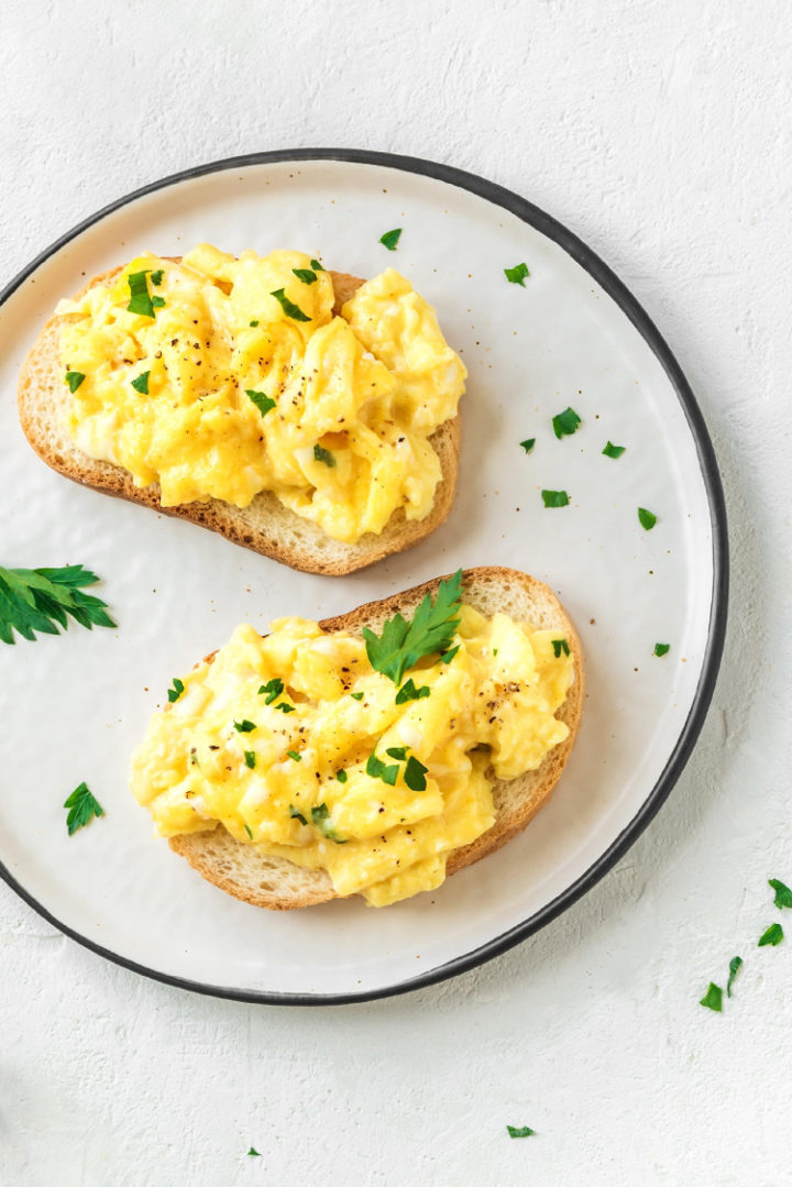 a photo of toast with scrambled eggs on top