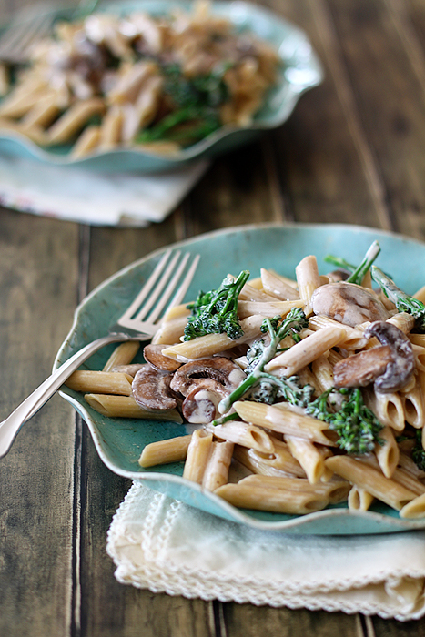 photo of pasta alfredo with mushrooms and broccoli on plates with a fork