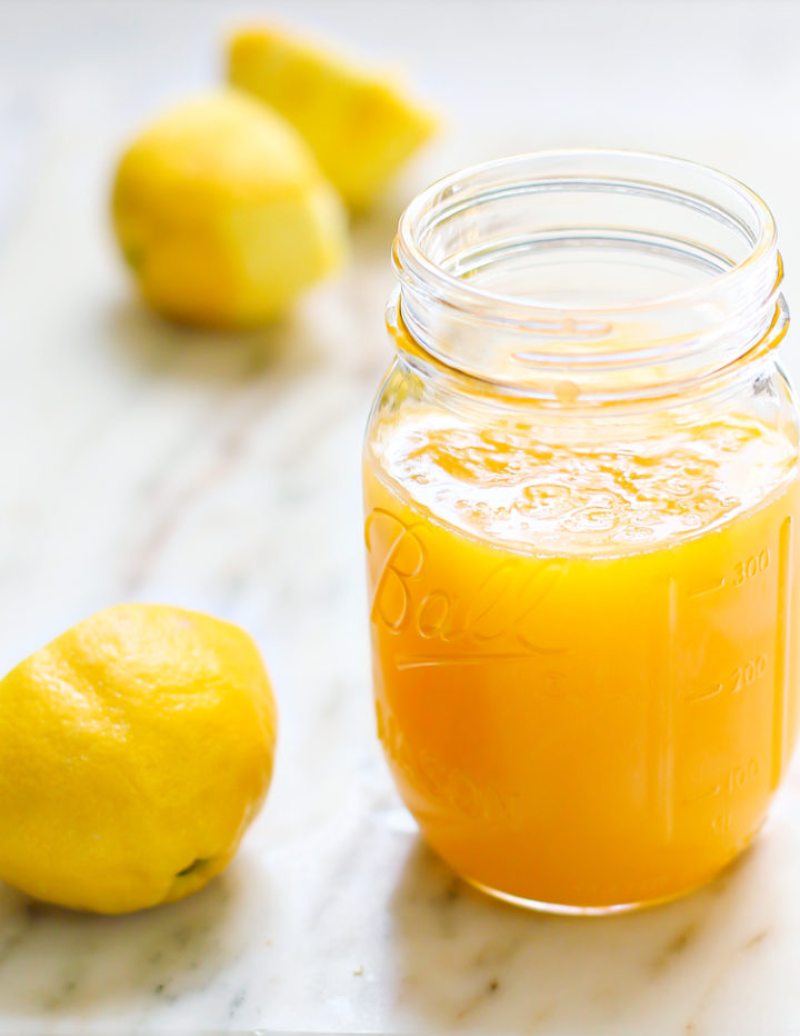 photo of a jar of lemon curd with fresh lemons