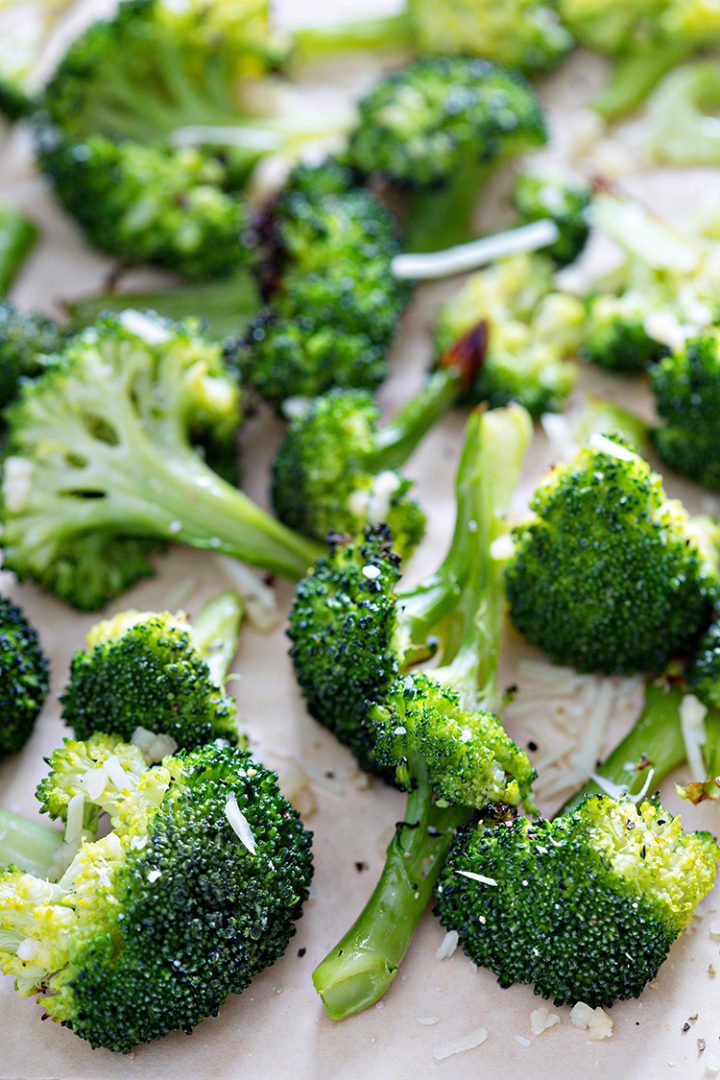 photo of roasted broccoli florets on a lined baking tray
