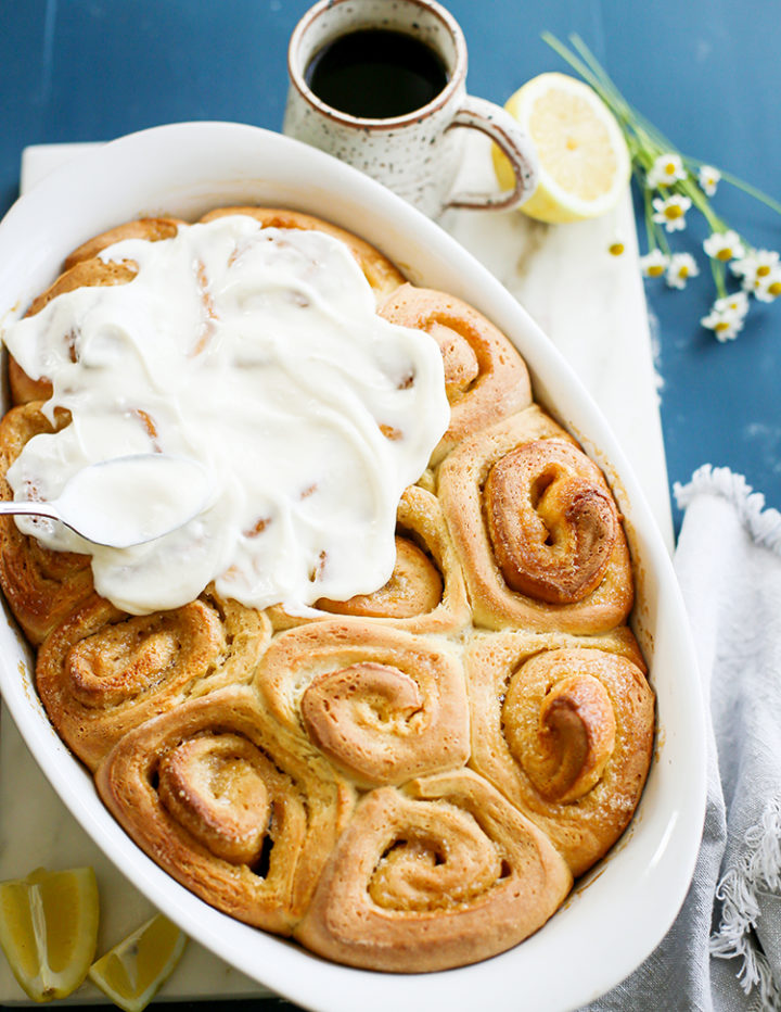 photo of lemon rolls with lemon cream cheese icing in a white baking pan
