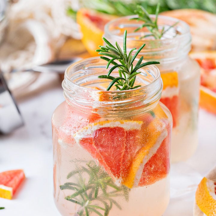 photo of a vodka tonic with grapefruit and rosemary served in mason jars