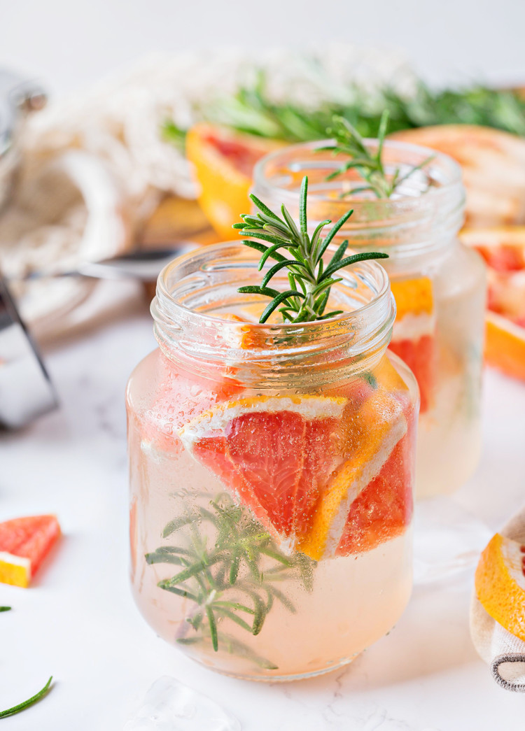 photo of a vodka tonic with grapefruit and rosemary served in mason jars