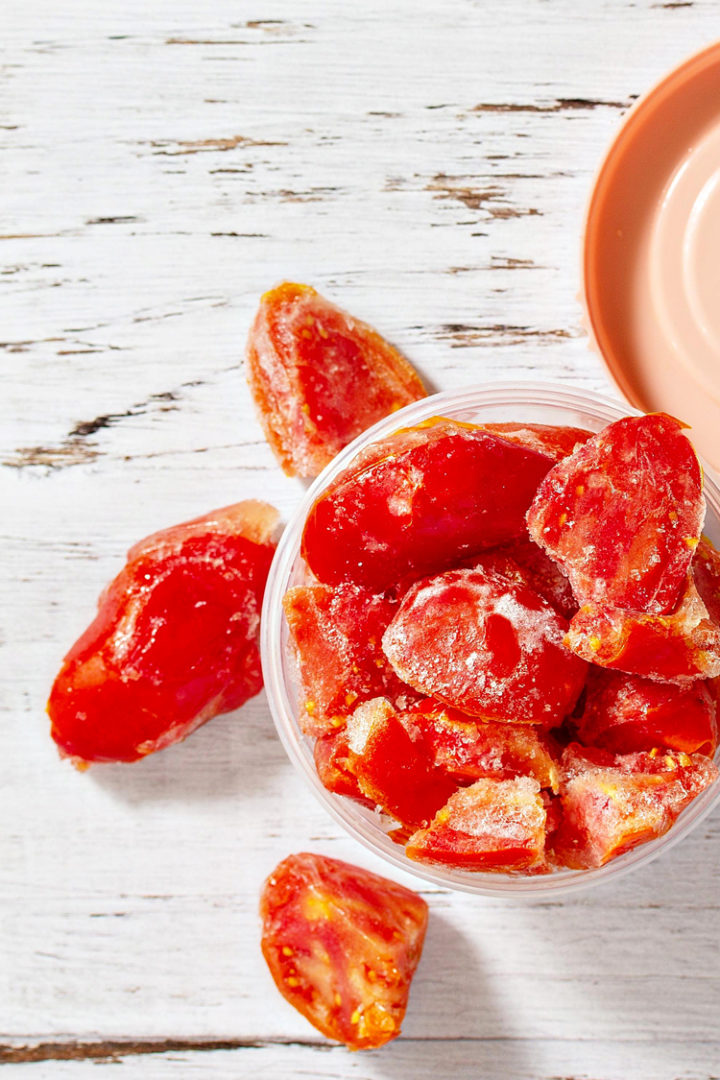 a photo of frozen tomatoes in a storage container