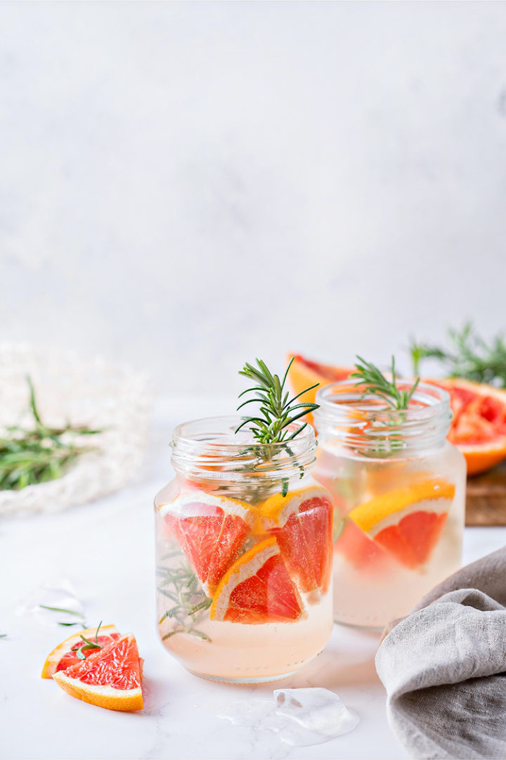 photo of two glasses of vodka cocktails with grapefruit and rosemary