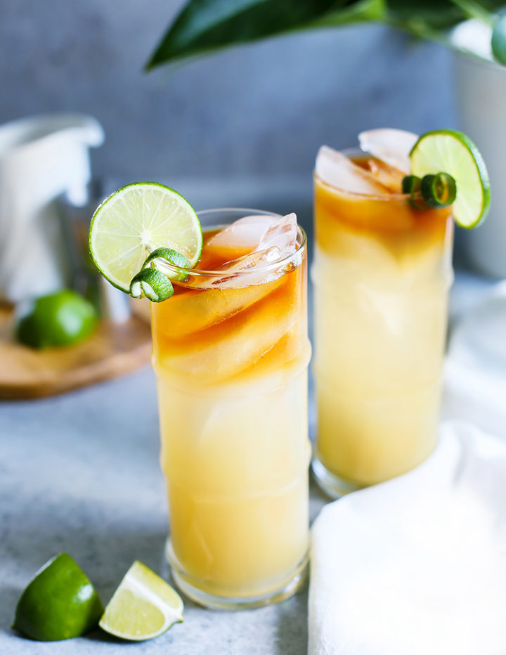 photo of two mai tai cocktails on a table with garnishes and table linens