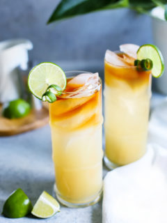 photo of 2 glasses of a mai tai garnished with limes