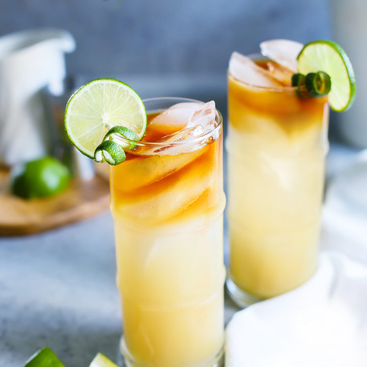 photo of 2 glasses of a mai tai garnished with limes