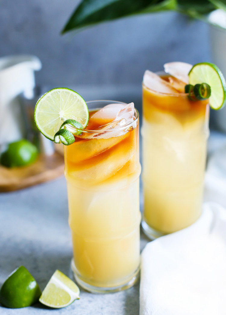 photo of 2 glasses of a mai tai garnished with limes
