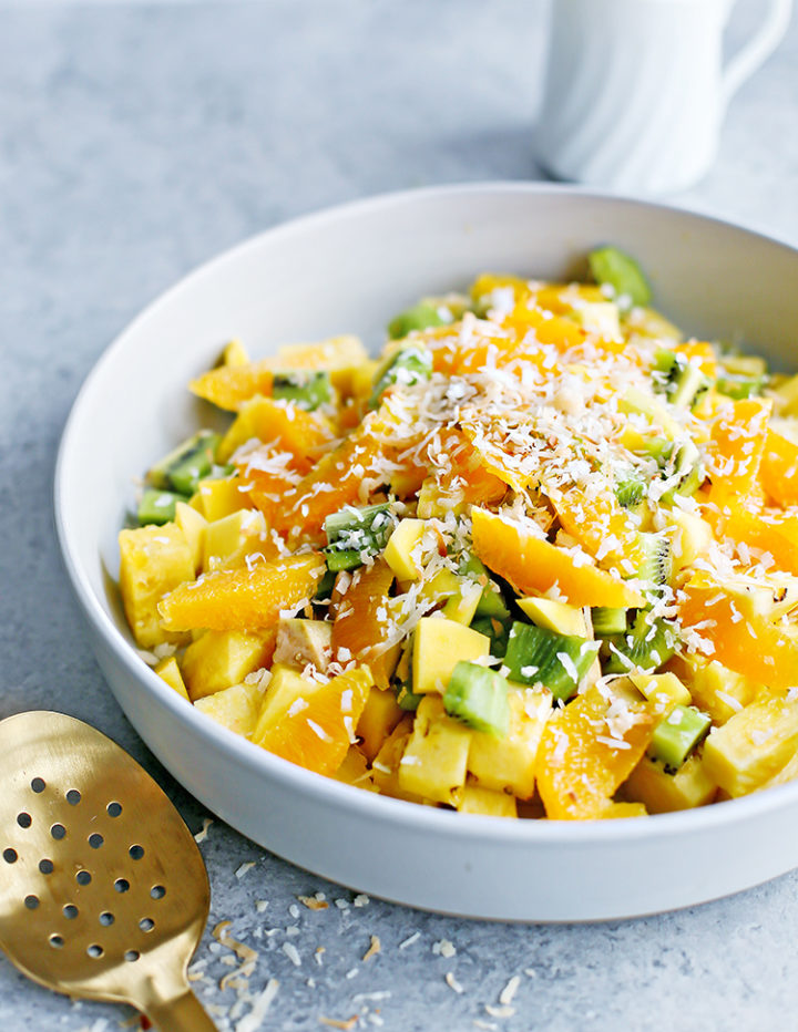 a photo of tropical fruit salad in a serving bowl with a spoon