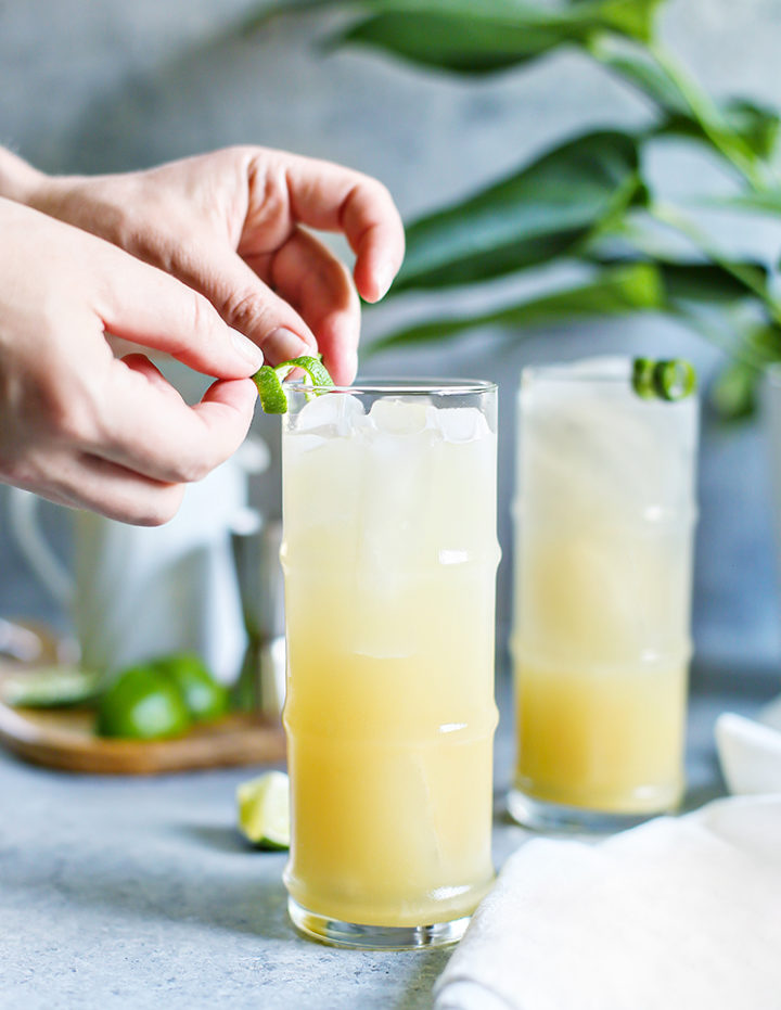 photo of a woman garnishing two glasses of mai tais