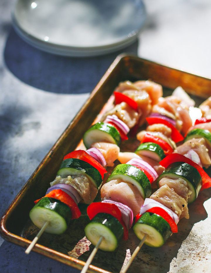 photo of skewers with vegetables and honey garlic lemon chicken on a tray ready to be grilled