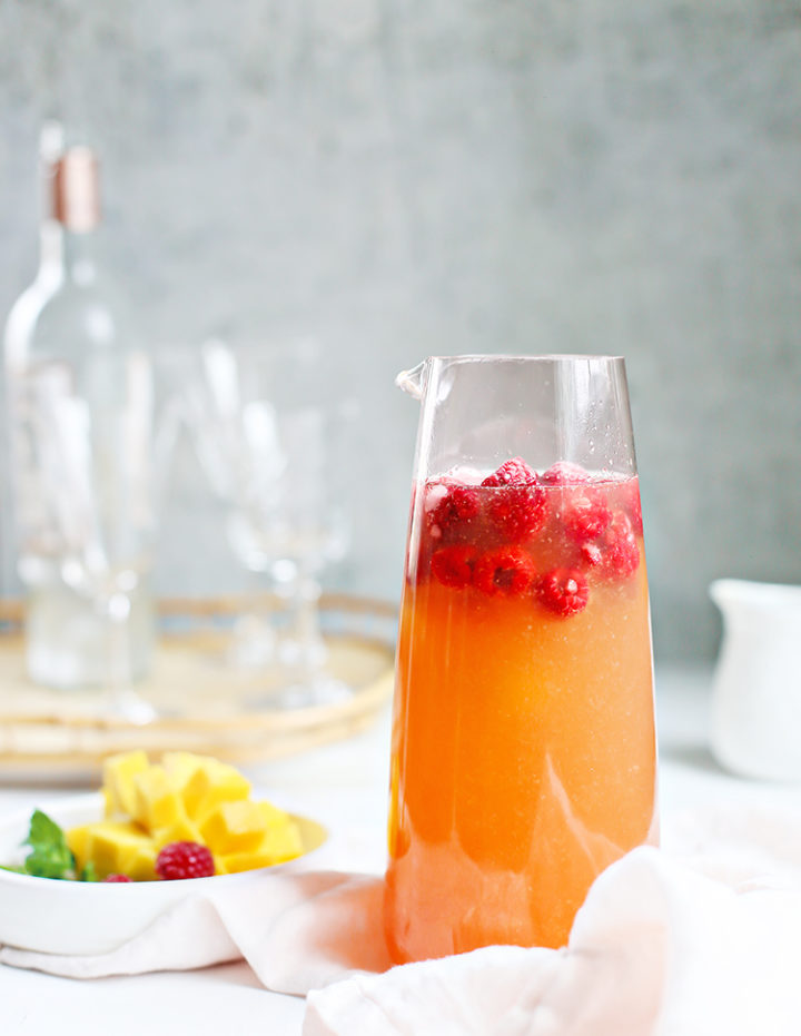 photo of a pitcher of raspberry mango sangria and a bowl of fruit