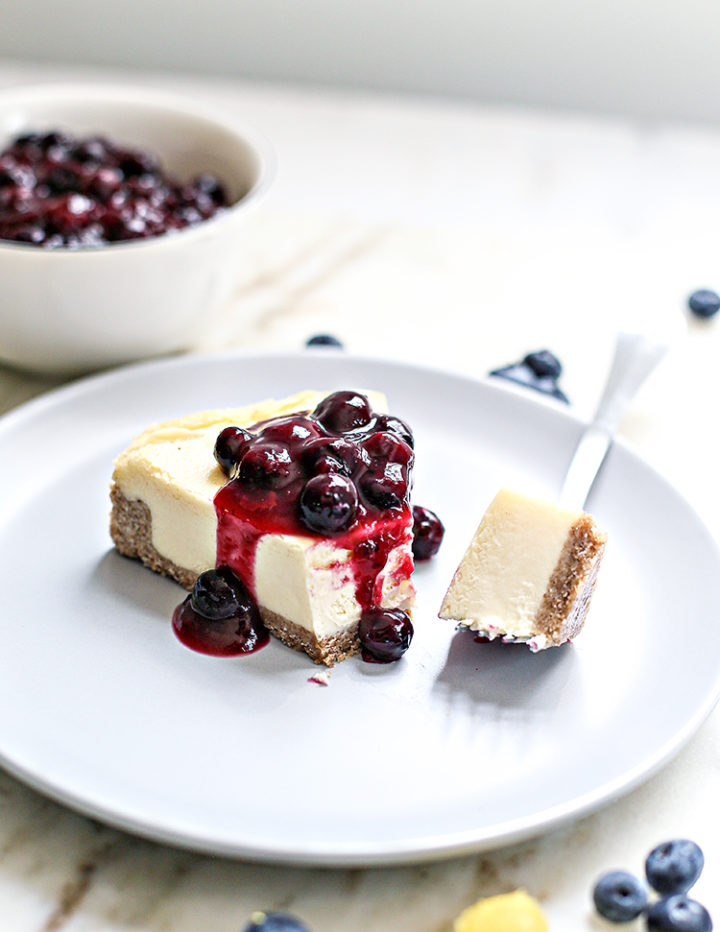 a slice of cheesecake with lemon blueberry sauce on top