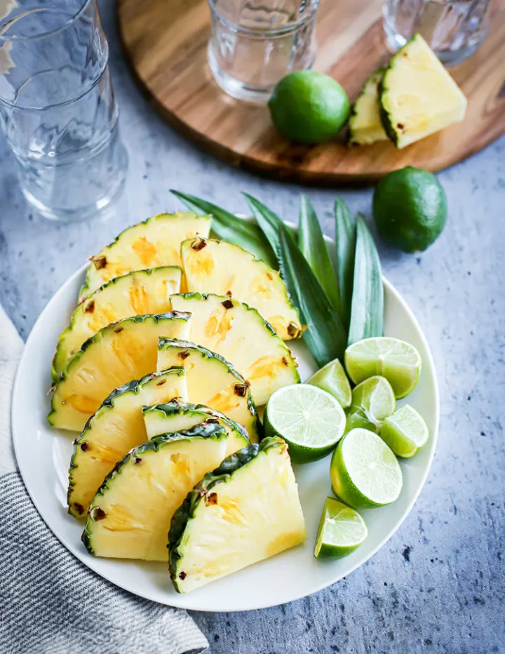 photo of fresh pineapple, limes, cocktail glasses, and other items needed to make a mai tai