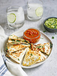 photo of veggie quesadilla on a plate with salsa and guacamole