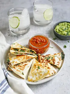 photo of veggie quesadilla on a plate with salsa and guacamole