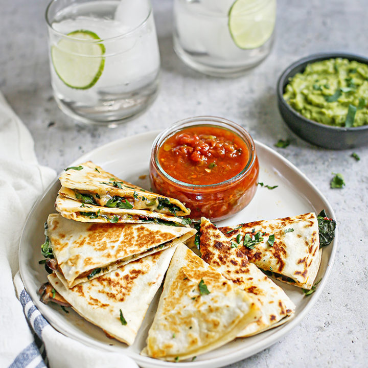 photo of veggie quesadilla on a plate with salsa and guacamole