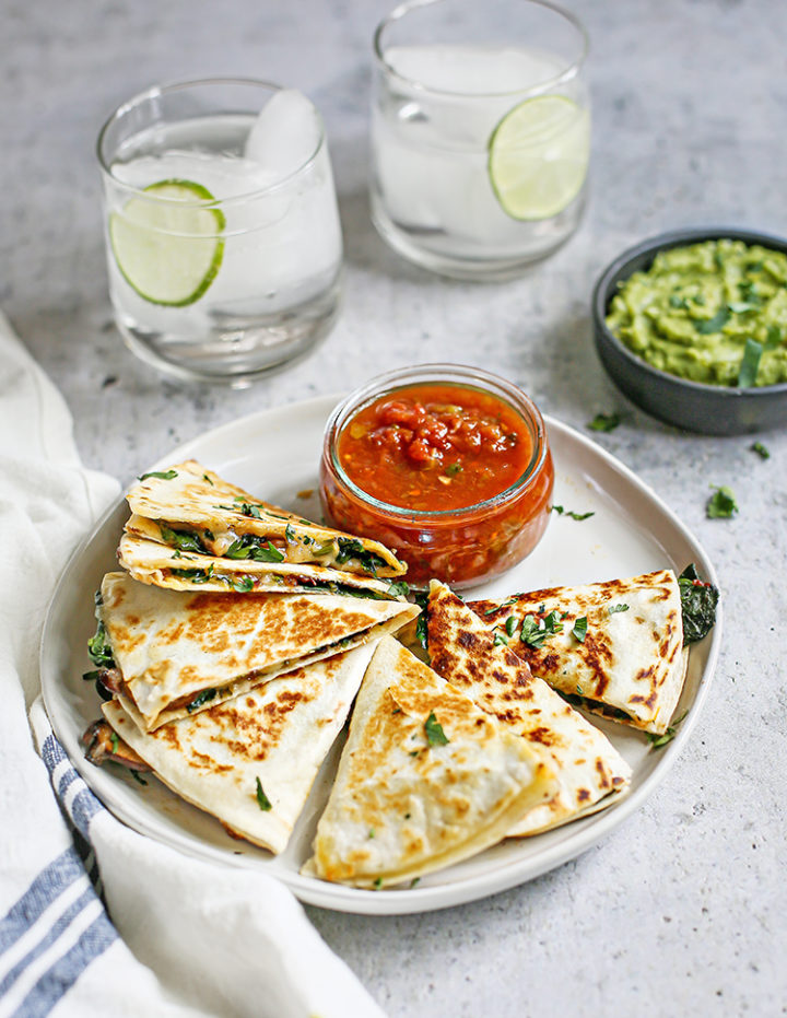 photo of a veggie quesadilla on a plate with a bowl of salsa