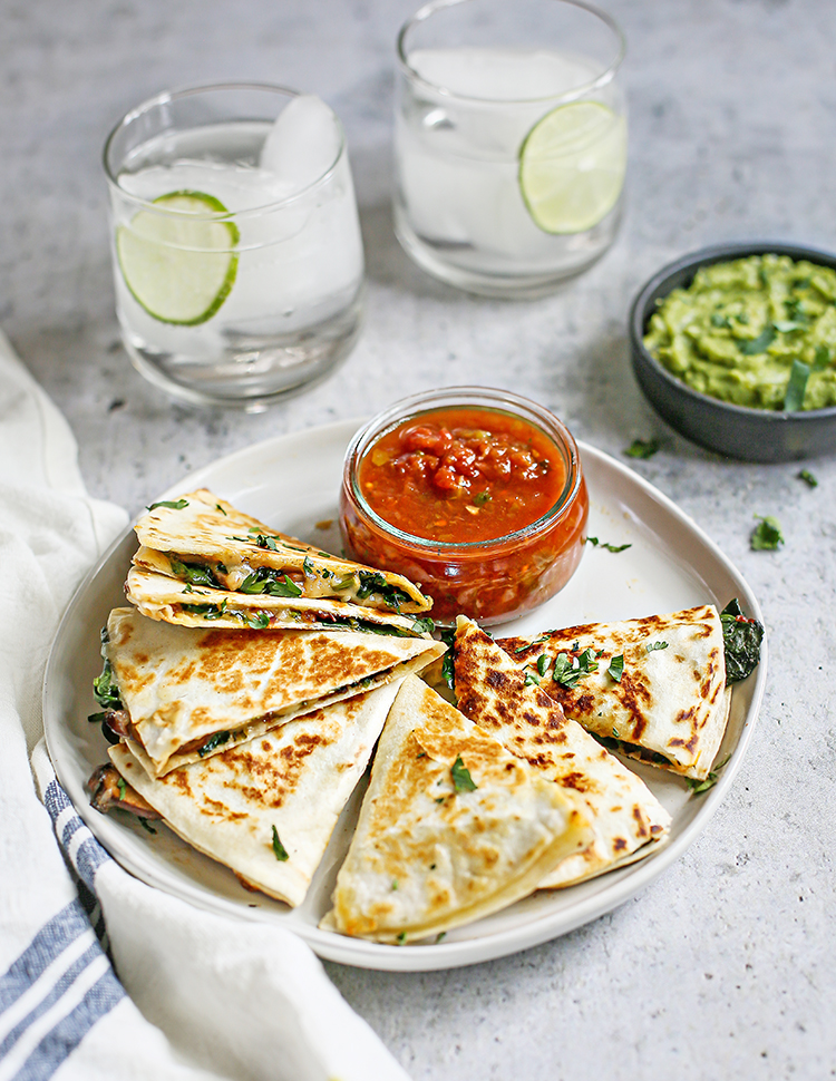 photo of veggie quesadilla on a plate with salsa and guacamole