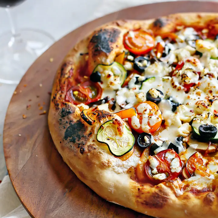 supreme veggie pizza on a wooden board