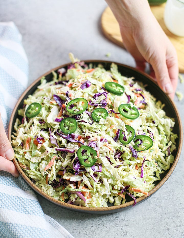 woman holding a bowl of jalapeño coleslaw j