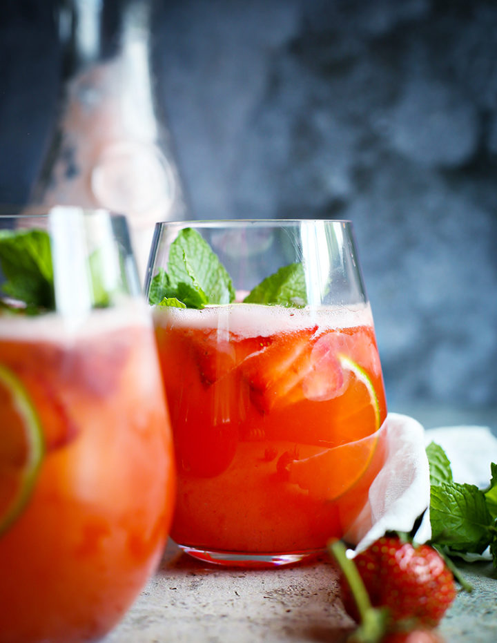 photo of two glasses of agua fresca with strawberry, lime, and mint
