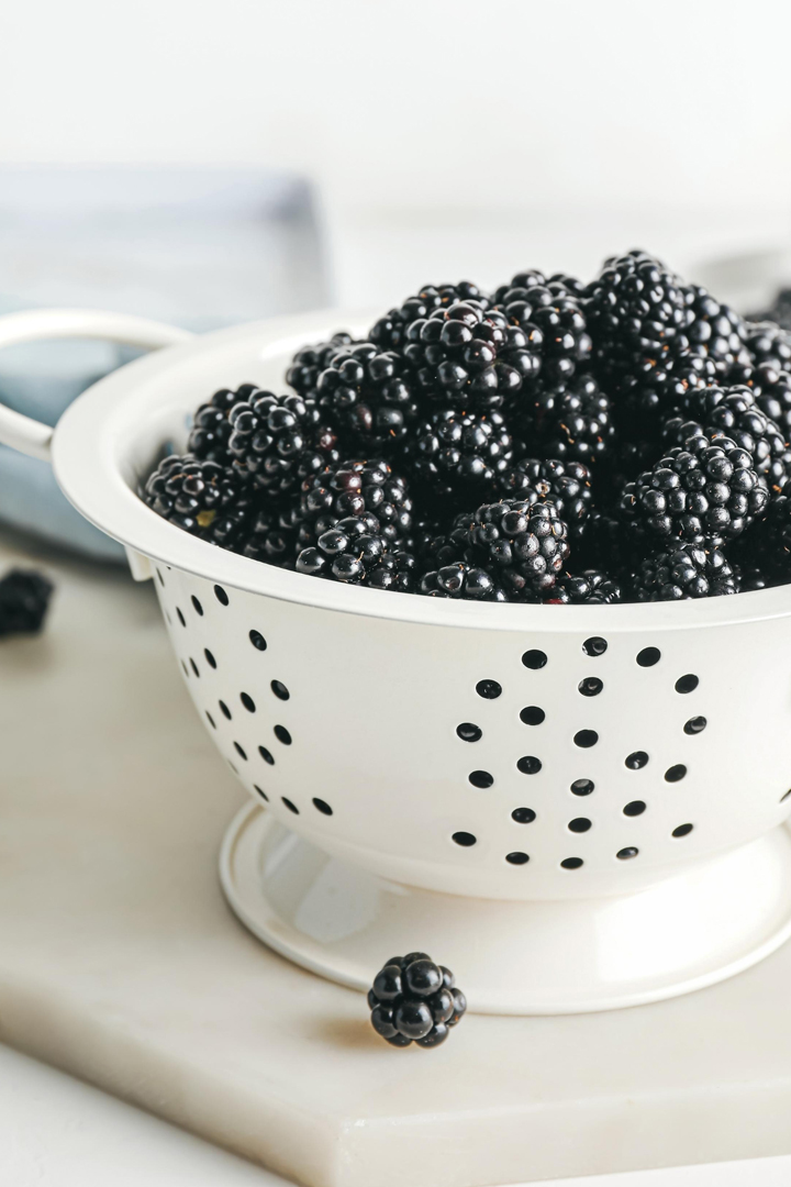 a photo of blackberries in a colander for a tutorial on how to freeze blackberries