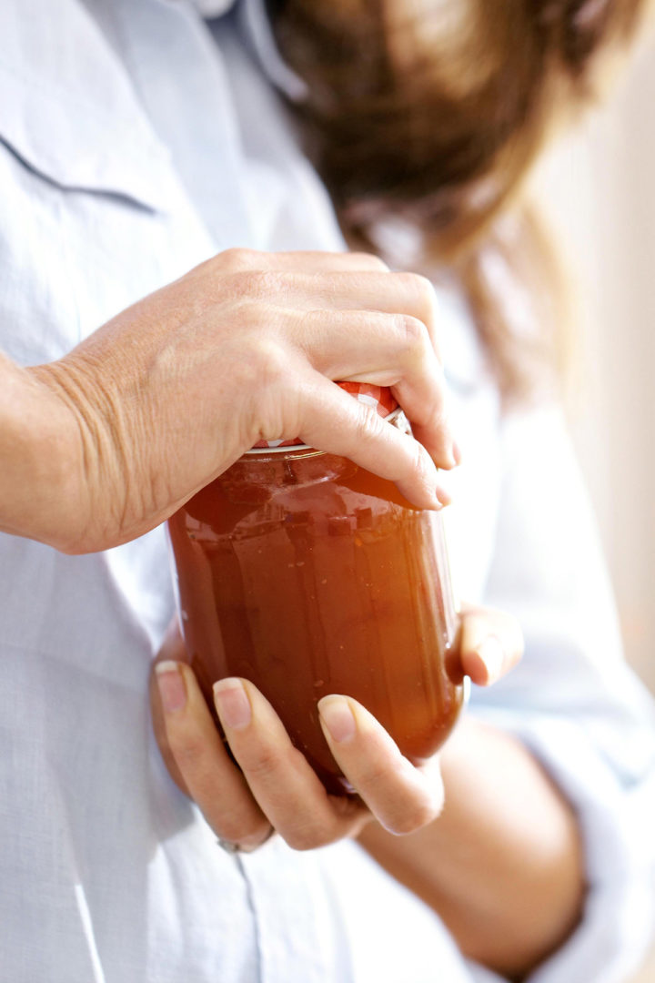 photo of a woman trying to open a jar with a tight lid