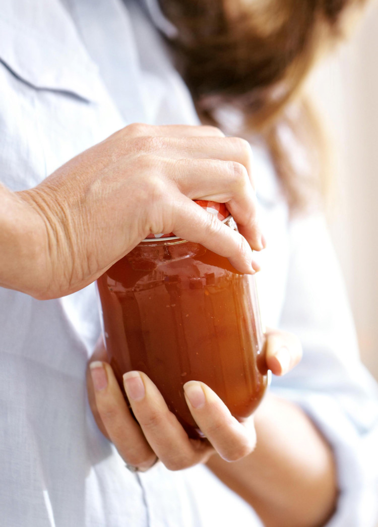 photo of a woman opening a jar with a tight lid